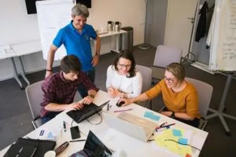 Des individus concentrés sur leurs ordinateurs portables dans un environnement de bureau dynamique.