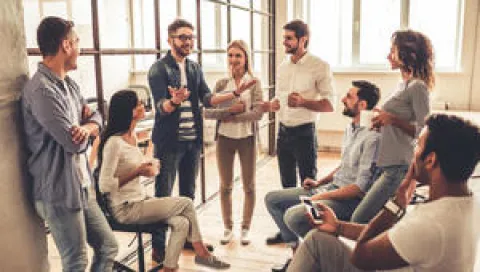 Plusieurs individus réunis dans un bureau discutant et travaillant en équipe.