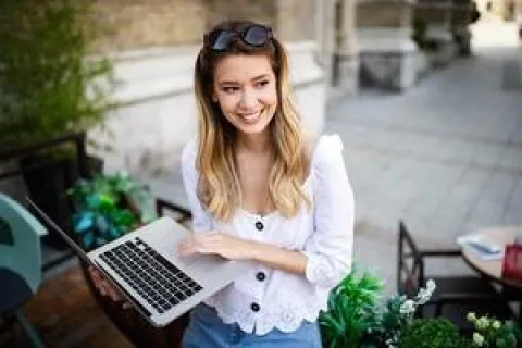 Le Compte Personnel de Formation, comment ça fonctionne Une femme arrêtée tient son ordinateur portable.